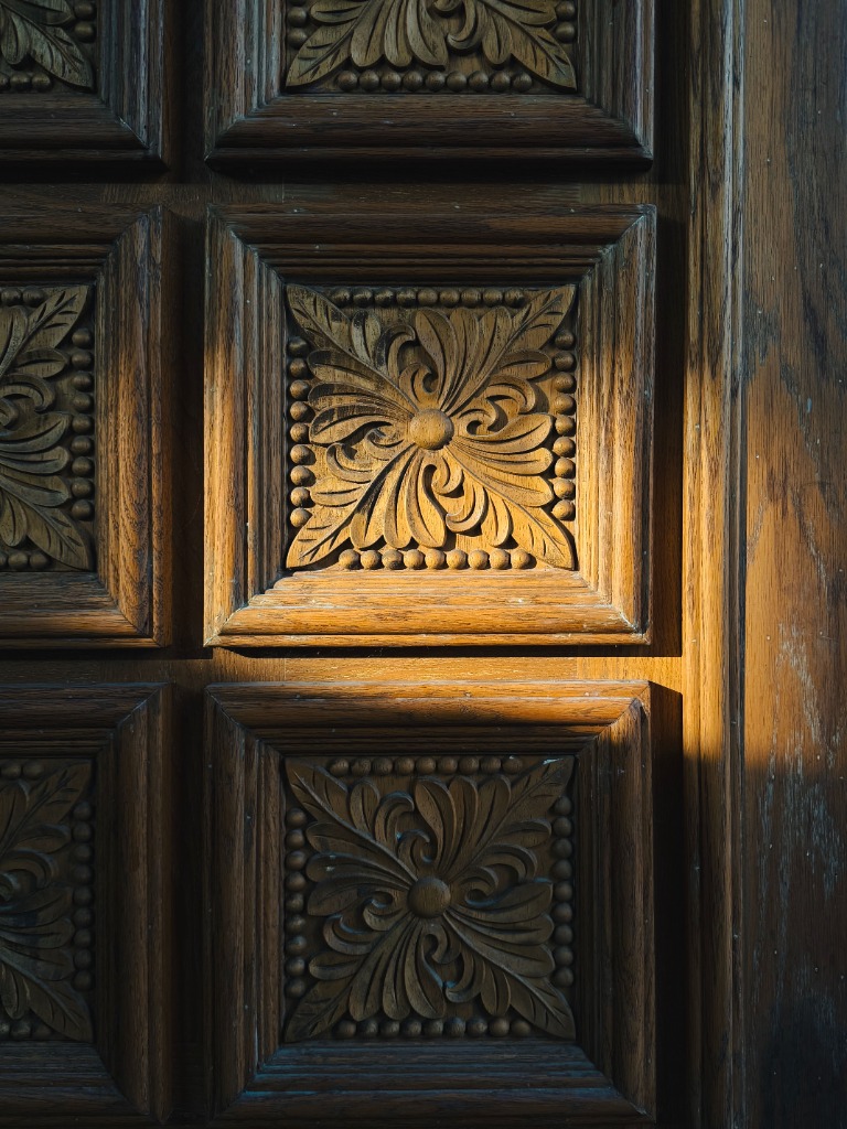 Hand-finished solid wood panel featuring carved square floral relief rosettes